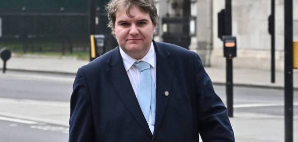 Conservative MP Jamie Wallis walks down the street wearing a white shirt, light blue tie and a suit jacket