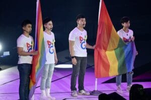 Athletes stand with rainbow flags