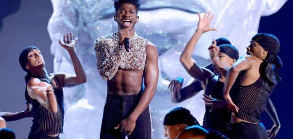 Lil Nas X in a mesh crop top surrounded by dancers