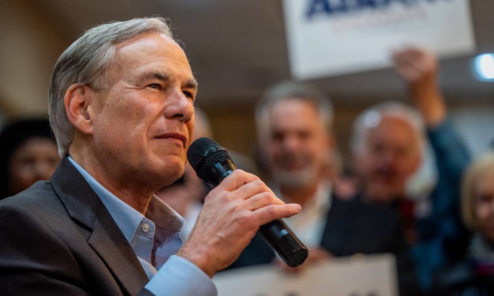 Texas governor Greg Abbott speaks into a microphone during a rally