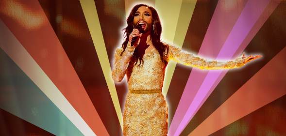 Conchita Wurst performing with retro rainbow backdrop.