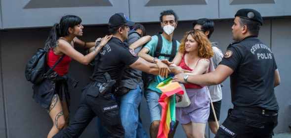 A Turkish policeman detains a demonstrator during a Pride march in Istanbul