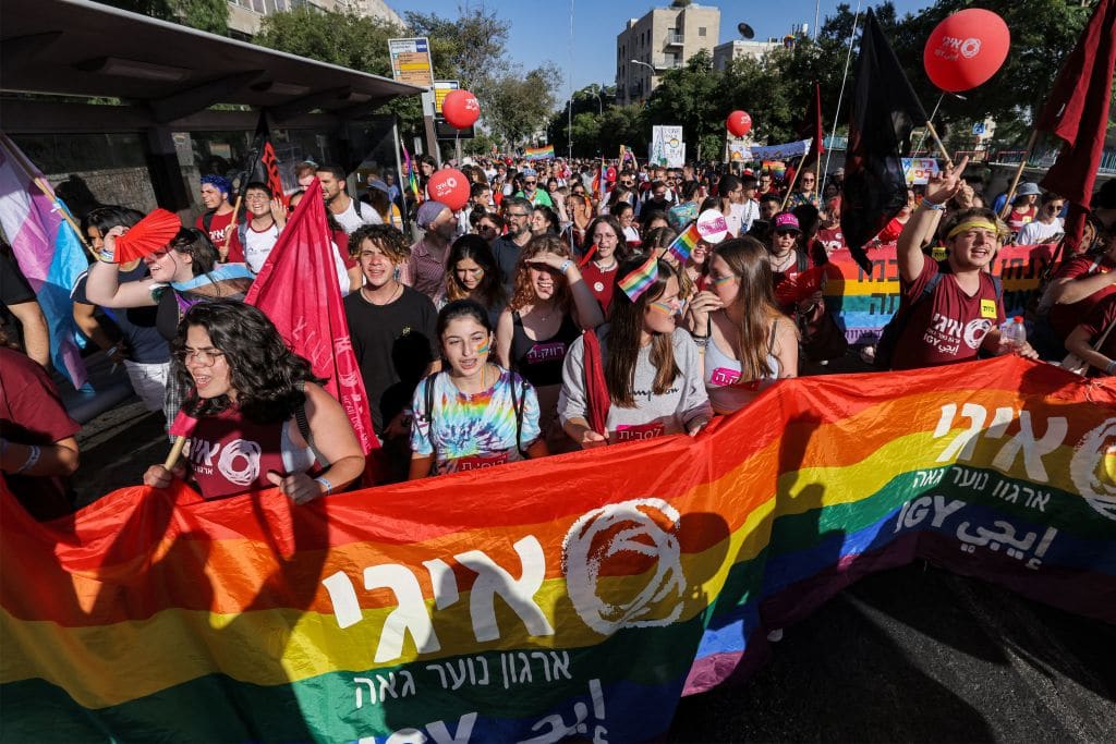 Participants march with a giant rainbow banner showing the logo of the "Israel Gay Youth" (IGY) NGO