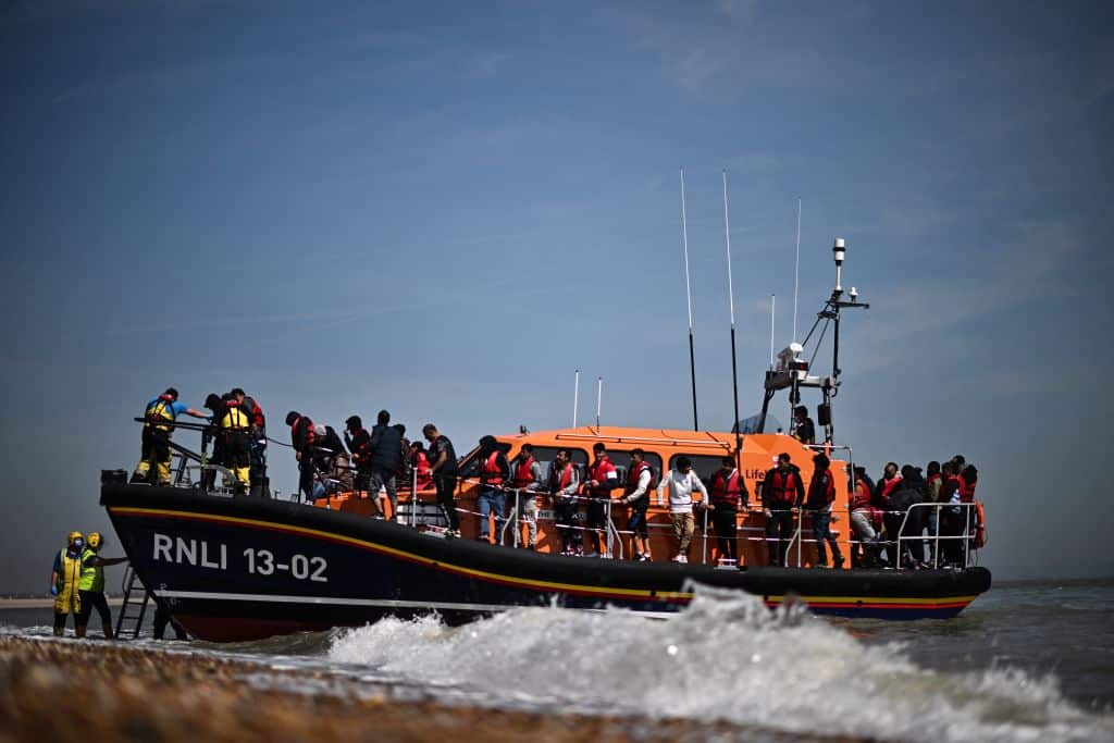 Migrants, picked up at sea attempting to cross the English Channel, are helped ashore from an Royal National Lifeboat Institution's (RNLI) lifeboat at Dungeness on the southeast coast of England. 