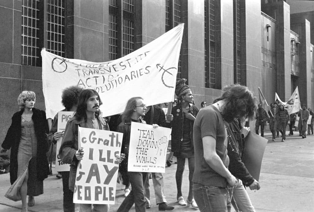 Two people carry the banner "Street Transvestite Action Revolutionaries" with the group's founders Sylvia Rivera and Marsha P. Johnson. 
