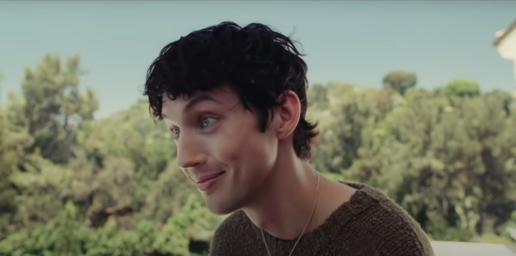 Troye Sivan in The Idol turned to the side smiling