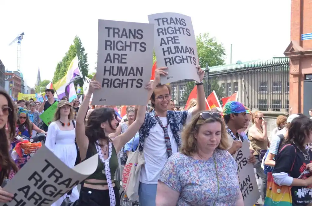 Crowds holding signs saying trans rights are human rights