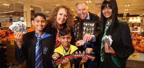 Coles customers hold packs of the collectable Harry Potter Magical Builders