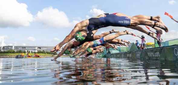 Athetes dive during the mixed relay Triathlon competition at the 2020 Tokyo Olympic Games