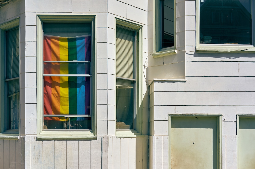 A Pride flag in the window of a house 