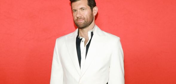 Promotional still of comedian Billy Eichner wearing a black shirt and white suit jacket.