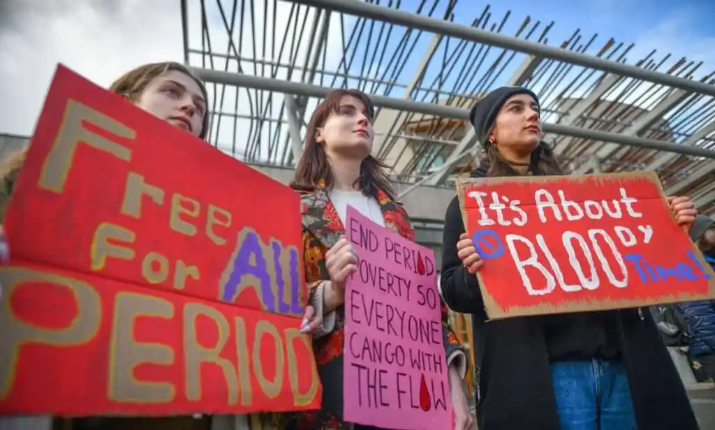 A crowd of people gather together to protest against period poverty