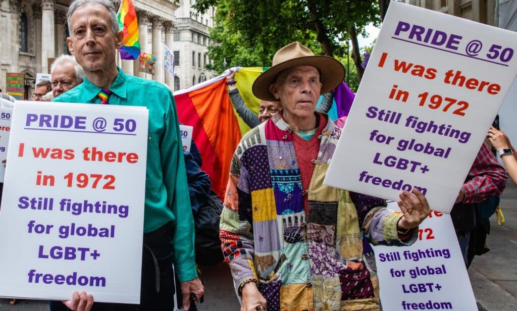 Peter Tatchell stands next to another LGBTQ+ activist during a march