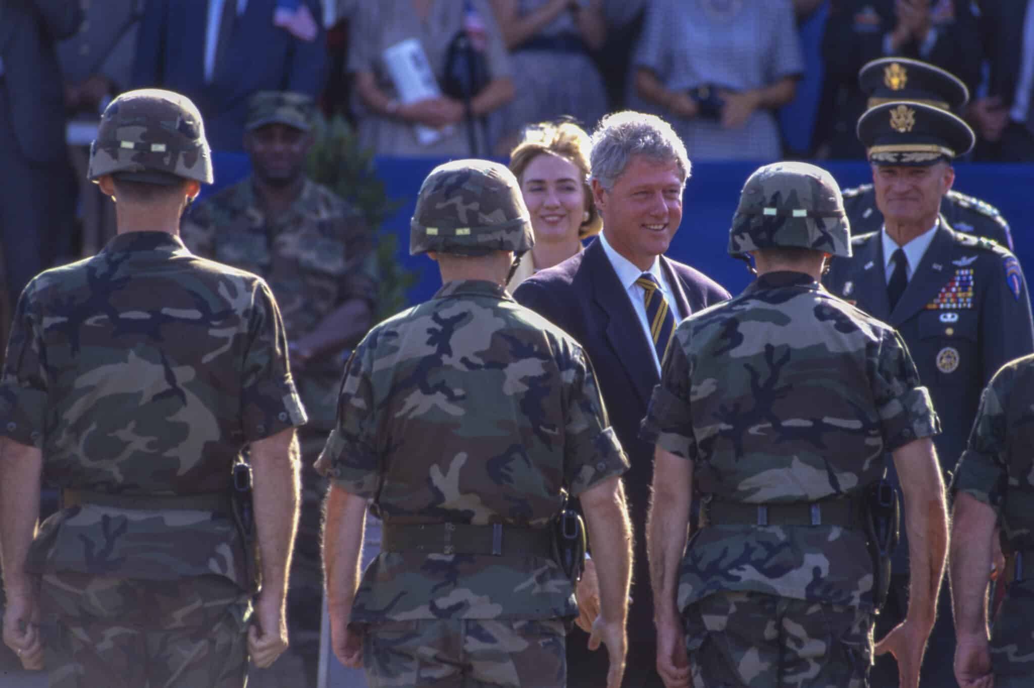 Bill Clinton walking past military personnel