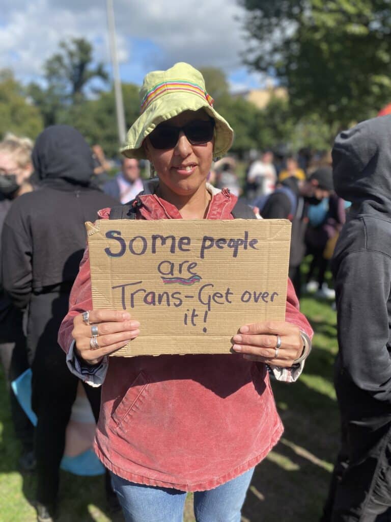 Protestor holds card for trans rights