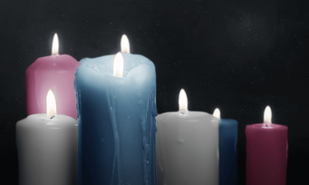 Lit candles in the colours of the trans Pride flag