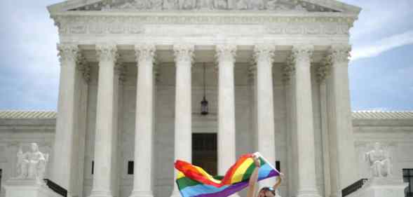 Joseph Fons holding a Pride Flag, walks back and forth in front of the U.S. Supreme Court