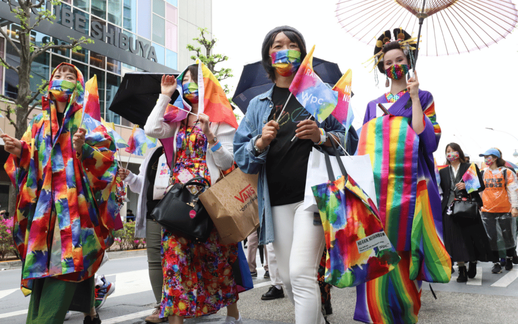 A photo shows LGBTQ+ activists marching in a Tokyo Pride parade.