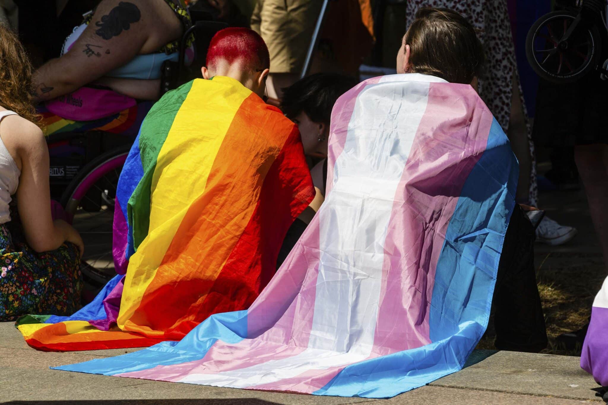 Protesters draped in Rainbow Pride and Transgender flags wait to take part in a London Trans+ Pride march. 