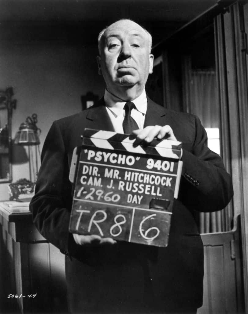 Alfred Hitchcock holding up a clapperboard on the set of Psycho.