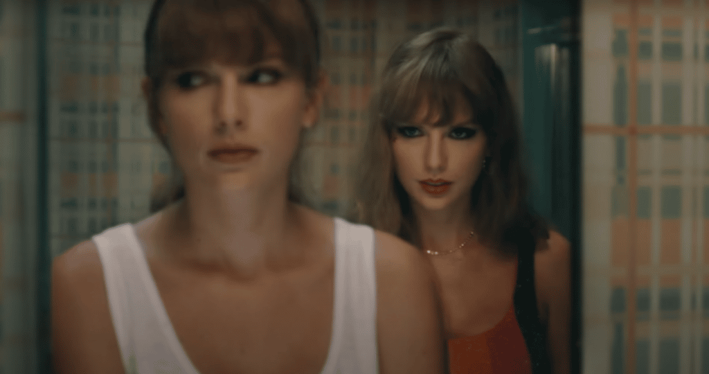 Taylor looking in a mirror with evil Taylor behind her