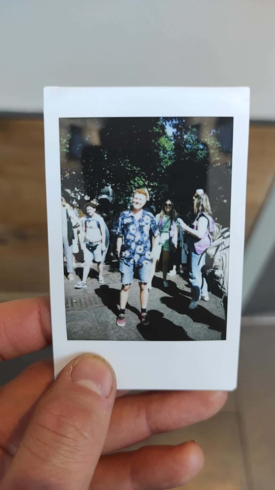 A polaroid of Nate standing in the sun at trans pride