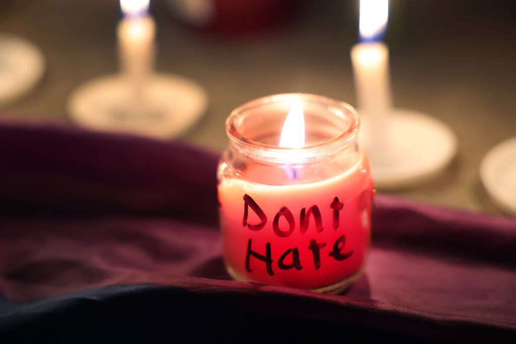 A candle with a message burns at a makeshift memorial near the Club Q nightclub on November 20, 2022 in Colorado Springs, Colorado. 