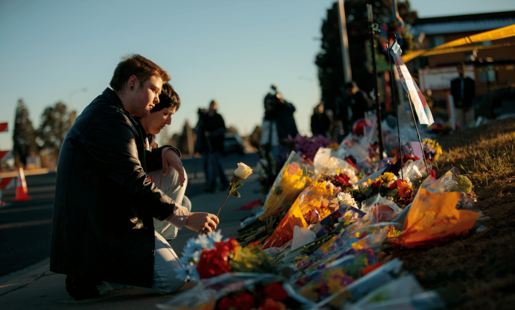 People leave flowers at the growing memorial at the scene of the shooting inside Club Q in Colorado Springs, Colorado