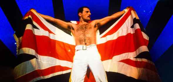 Freddie Mercury holding up a Union Jack on stage.