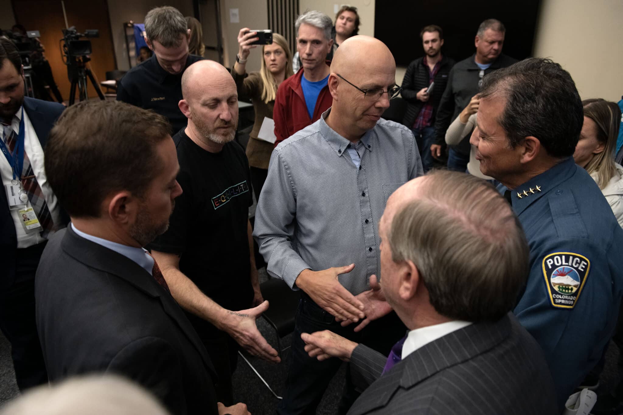 Club Q co-owners, Nic Grzecka, center left, and Matthew Haynes, center right, attend a press conference held by police in Colorado Springs.
