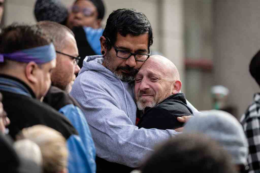 Club Q co-owner Nic Grzecka is hugged by mourners in front of Colorado Springs City Hall.