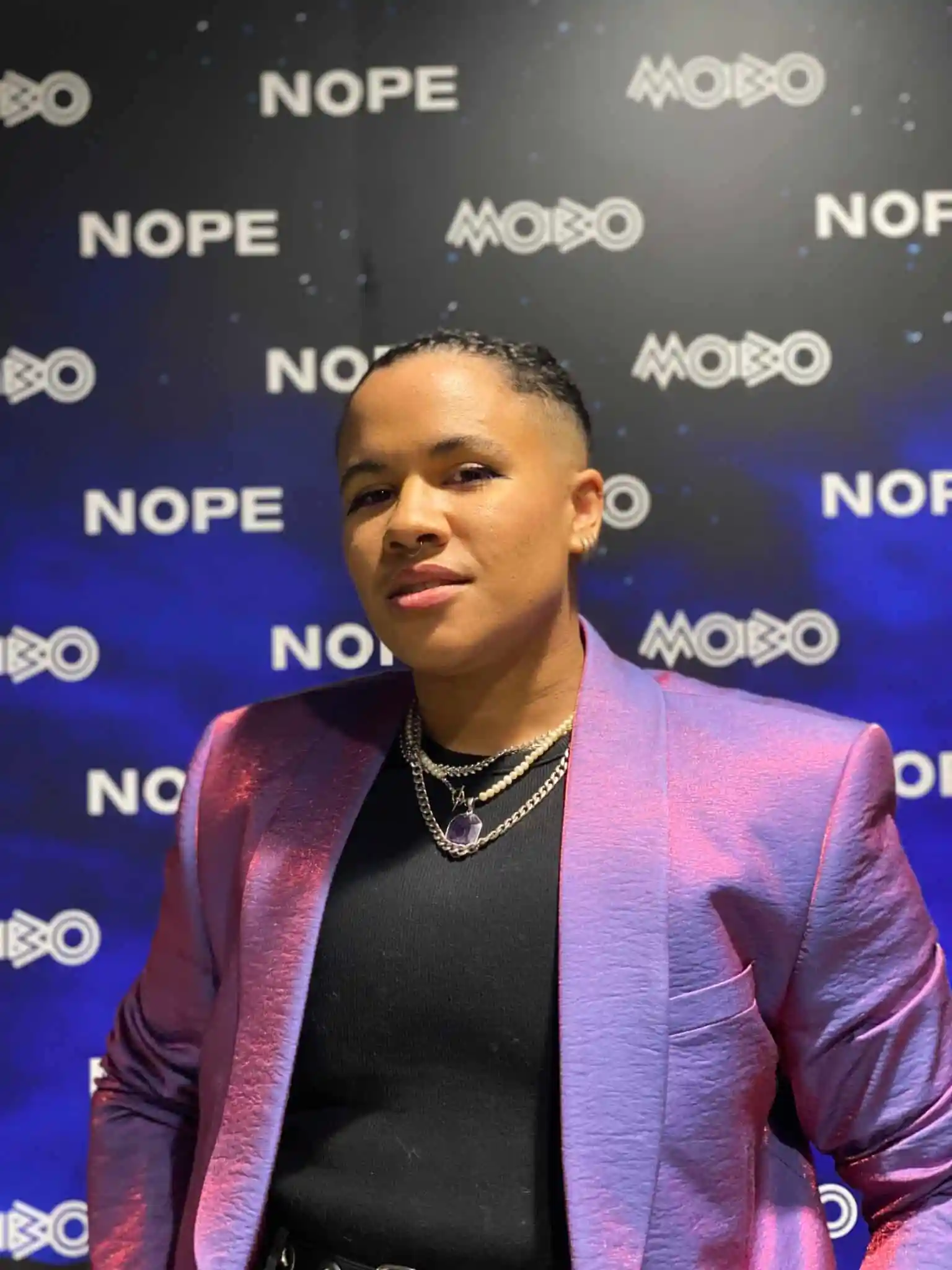 Ki Griffin wearing a purple blazer and a black top at an event.