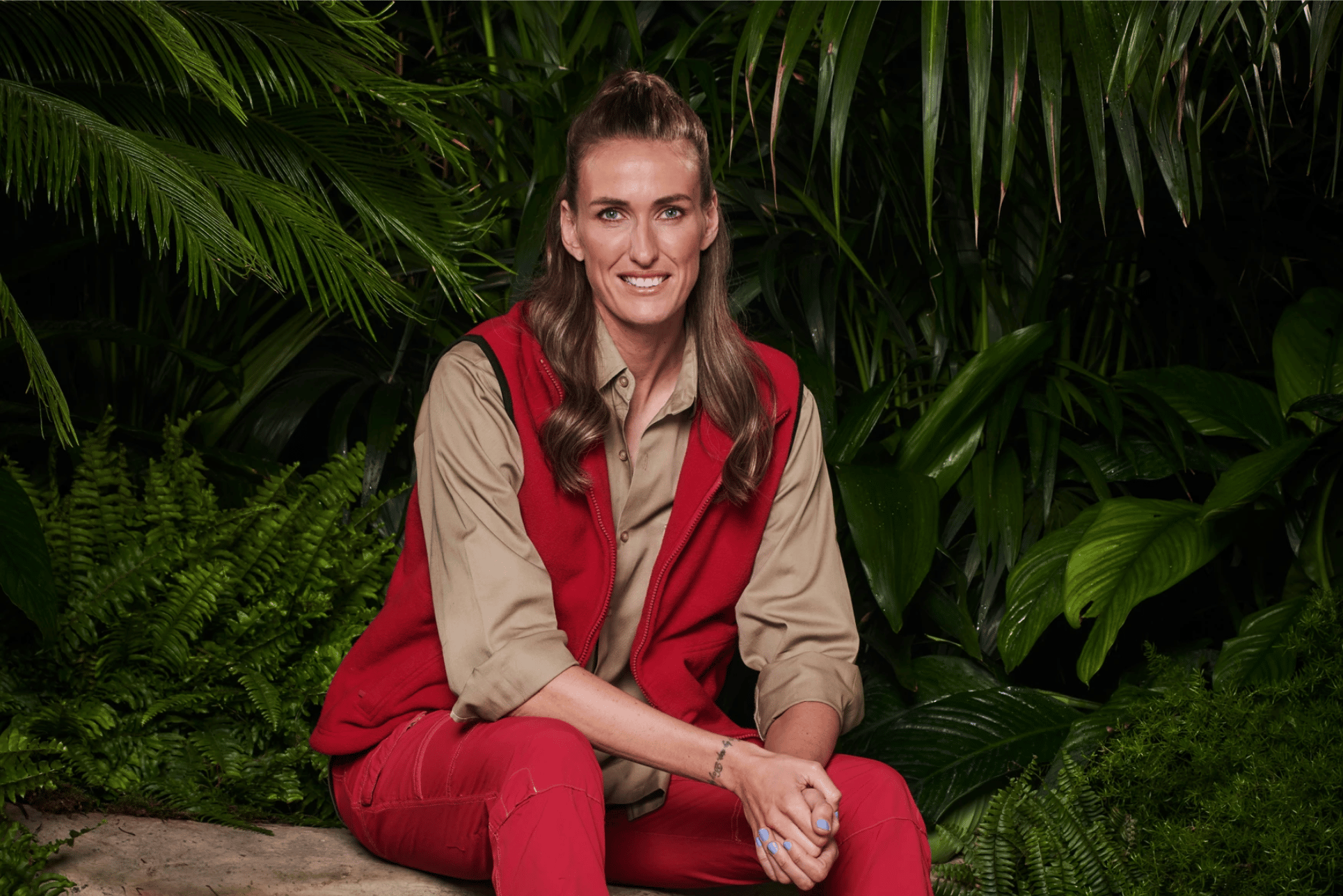 A promotional photo of England Lioness Jill Scott sitting in a jungle setting for the series I'm a Celebrity, Get Me Outta Here