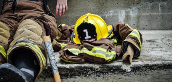 A firefighter sits on concrete steps