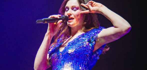 Sophie Ellis-Bextor singing into a microphone while doing a peace sign