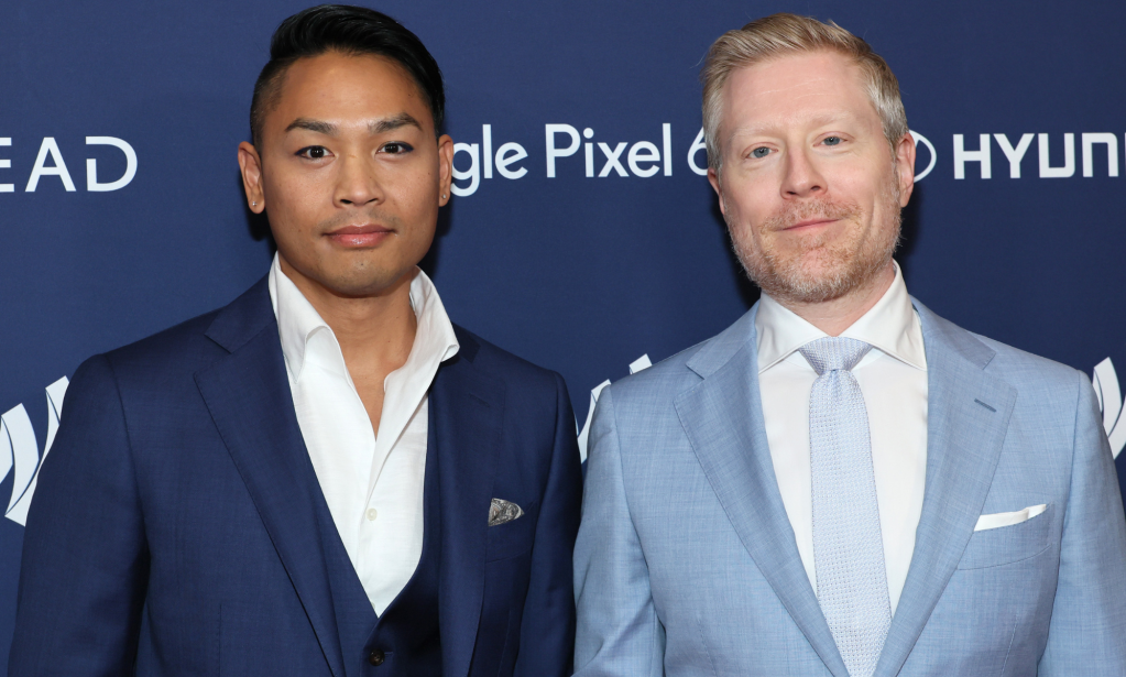 Ken Ithiphol and Anthony Rapp stand side-by-side while wearing blue suits