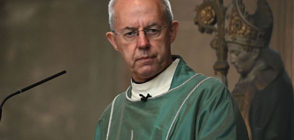 Archbishop of Canterbury, dressed in green robes, presides over a congregation.