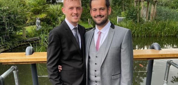 Ricardo and Bradleigh, a gay couple, wear suits and smile at the camera in an image shared as part of their promotion of fostering as a way to expand a family