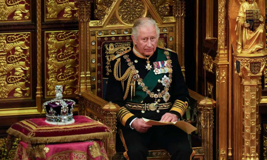 A photo of King Charles III sitting next to St Edward's Crown