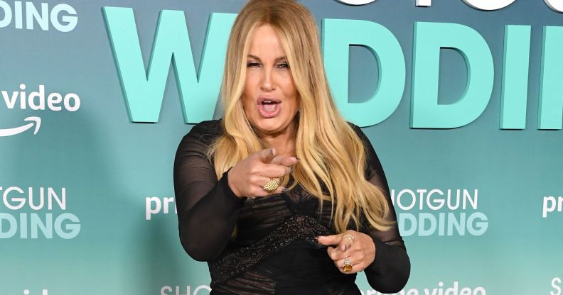 Jennifer Coolidge wearing a black dress at the Shotgun Wedding premiere, pointing at the camera with her mouth open.