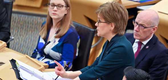 A screenshot of Nicola Sturgeon wearing a navy suit as she talks during First Ministers Questions at the Scottish Parliament