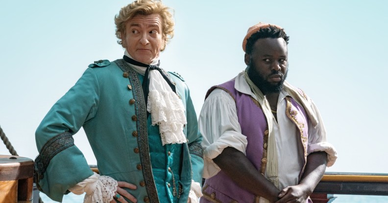 A still from HBO's Our Flag Means Death showing actors Rhys Darby and Samson Kayo dressed as pirates and standing on a ship