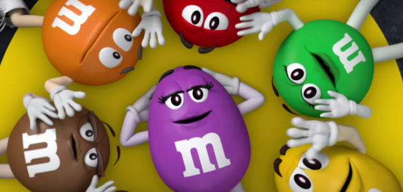 M&Ms characters in a circle surrounding the cartoon purple M&M