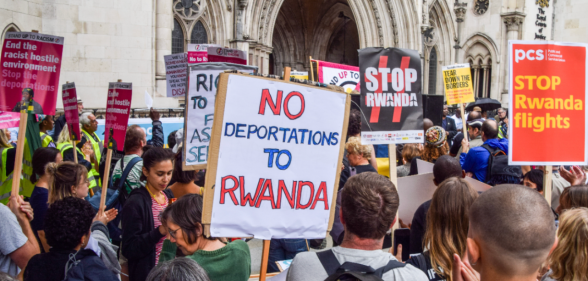 A protester holds a placard which states "No deportations to Rwanda" during a demonstration to halt deportations of refugees to Rwanda