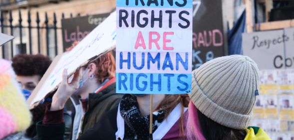 A trans rights supporter holds up a sign reading "Trans Rights are Human Rights" during a protest against the UK Goverment Section 35 stopping Scotland's gender recognition reform bill