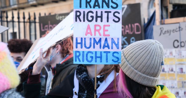 A trans rights supporter holds up a sign reading "Trans Rights are Human Rights" during a protest against the UK Goverment Section 35 stopping Scotland's gender recognition reform bill