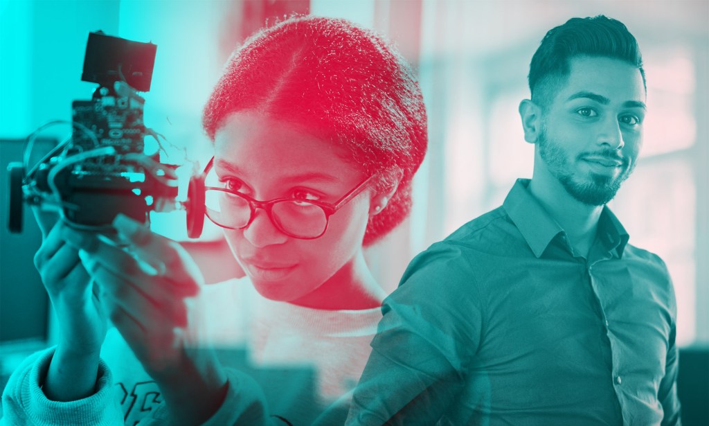 A woman is inspecting a piece of machinery. Next to her is a man looking at the camera.