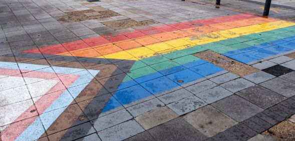 A pavement with an LGBT Pride flag on the tiles.