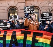 Counter-protestors hold up a rainbow banner and signs in support of the LGBTQ+ community while standing in solidarity with a Drag Story Hour event