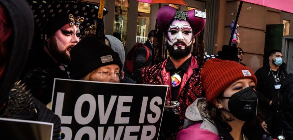 A person holds up a sign reading "Love is power" at a protest attended by LGBTQ+ people and allies in support of Drag Story Hour